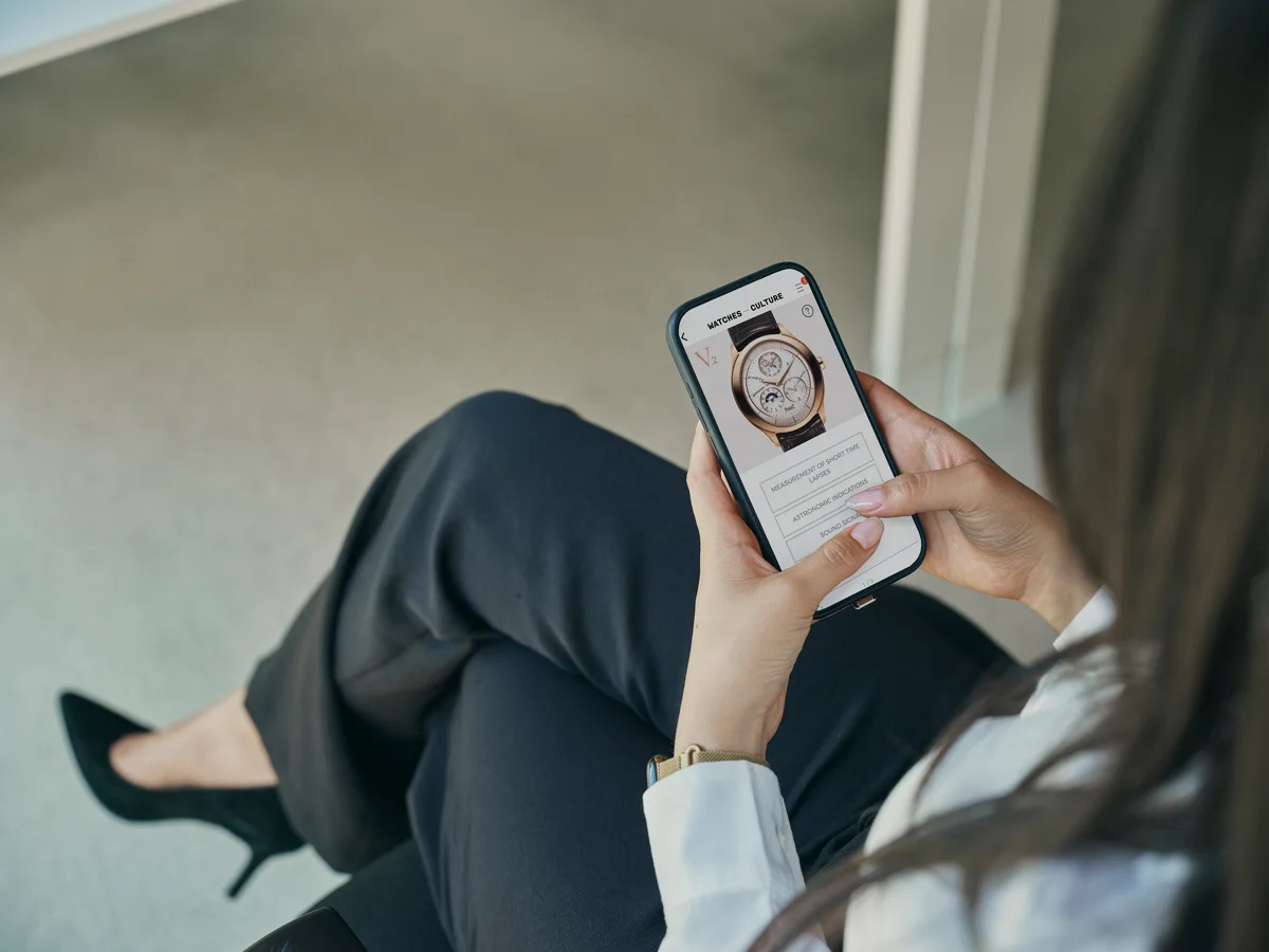 Une personne consulte la photo d’une montre sur son téléphone